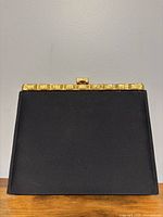 Front view showing black satin body and gold-tone metal frame