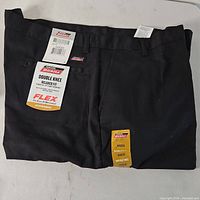 Front view of folded black Dickies pants showing waistband and tags