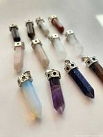 Group view of all 12 crystal point pendants with silver-tone bails.