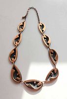 Full view of necklace laid flat showing all leaf links and extender chain