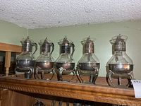 Five carafes aligned on shelf showing overall style and quantity