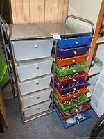 Full view of metal cart with six white drawers left and ten coloured drawers right