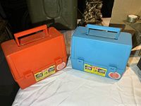 Orange and blue plastic lunch boxes side by side