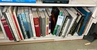 Row of tall hardcover books on bottom shelf