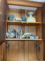 Cupboard interior with scale, metal boxes, funnels, straps, instruments on doors