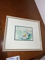 Framed watercolor painting sitting on table