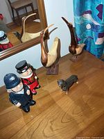 Group view of both wooden birds, ceramic figures, and porcelain dog