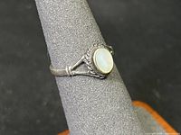 Side view of sterling silver ring showing mother of pearl cabochon and decorative setting