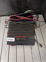 Top view of Pyramid PB-300G amplifier showing model marking, Gold Series branding, attached wiring harness