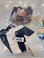 Plastic bag containing multiple scarves with note stating no tag/no brand visible