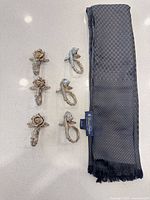 Necktie and six decorative metal pieces laid out