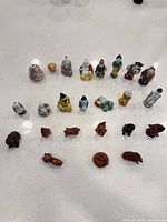 Full group of approximately 23 miniature figurines arranged on countertop