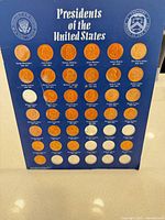 Full view of blue presidential coin display with tokens inserted