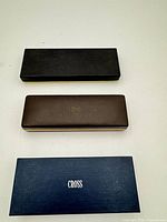 Three Cross branded presentation boxes black, brown, blue sleeve