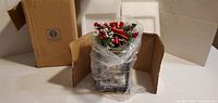 Lantern in open box with protective bag and holiday topper