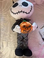 Front view of Jack Skellington plush holding pumpkin