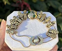 Bracelet on display pad showing children charms, globe charm, clasp