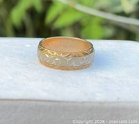 Side view of ring showing two-tone design and scroll engraving