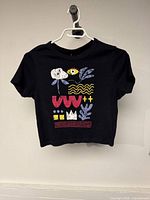 Front view of black crop top with abstract multicolor print