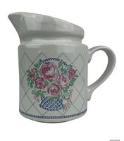 Front view showing floral basket pattern and pitcher form