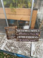Both wooden signs leaning against structure showing overall appearance