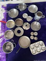 overview of full toy cookware set laid out on purple cloth