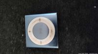 Front view of blue Apple iPod Shuffle showing control pad and wear