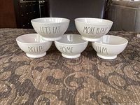 Front view displaying text on all five bowls in pyramid arrangement