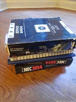 Stack showing service manual, spiral-bound NEC 2014, NEC 2014 paperback