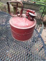 Side view of red metal Chicago fuel can on mesh table