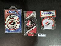 Three Team Canada items: coaster in blister, koozie in plastic, mini jersey pouch with keychain in blister
