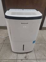 Front view of Honeywell dehumidifier showing brand label and water-level window