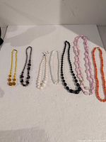 All seven necklaces laid out showing colours and styles