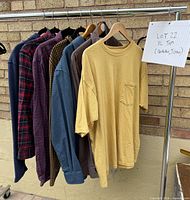 Front view of six XL tops on rack including yellow T-shirt and assorted long-sleeve shirts