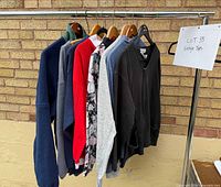 Eight tops hanging on metal rack