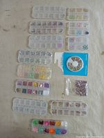 Full layout showing 13 organizer boxes, sealed wheel package and bag of rhinestones