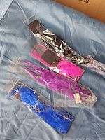 All four packaged feather extensions laid out showing colours and chains