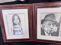 Both framed graphite portraits side by side