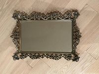 Full view of rectangular brass vanity mirror tray showing ornate border and mirror surface
