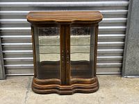 Front view closed showing wood finish and curved glass doors
