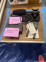 Lot staged showing microphone with windscreen and mount, Beachtek adapter, cable, tripod legs and manual