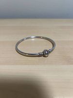 Full view of closed sterling silver bangle bracelet on light background