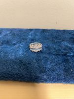 Front view of sterling silver CZ band ring on blue fabric