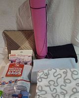 Group shot showing yoga mat, Singer Handy Stitch box, vacuum bag pack, three blankets, and cushions