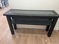 Full view of black console table with glass panel and shelf