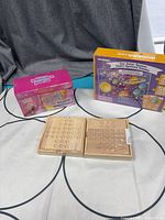 Lot overview showing two wooden peg games, Pom Pom Purse kit, Quokka puzzle