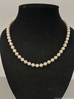 Necklace displayed on black bust showing full strand