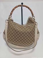 Front view showing GG monogram canvas, bamboo handle, leather strap and trim