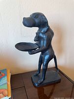 Front view of black cast iron dog statue holding tray