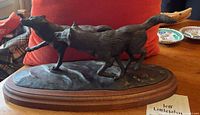 Side view of bronze sculpture on wood base